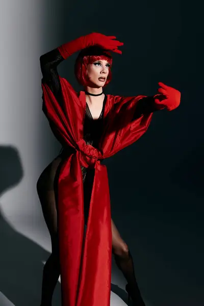 A stunning drag queen poses artfully in a bold red outfit, exuding charisma and flair. — Stock Photo