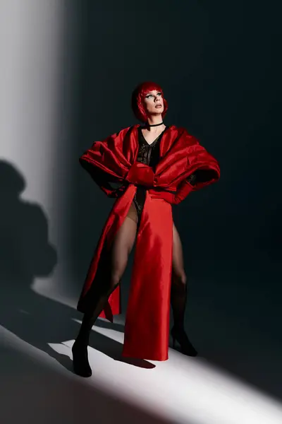 Una drag queen confiada muestra su impresionante atuendo y posan en una iluminación dramática. - foto de stock