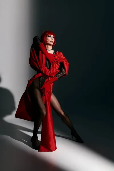 A stunning drag queen showcases artistry and grace in a vibrant red outfit. — Stock Photo