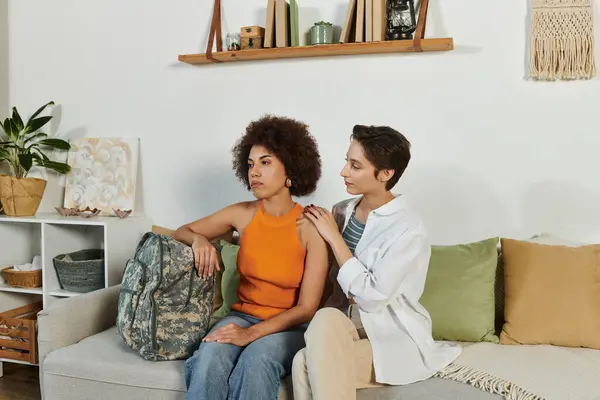 A heartfelt farewell in a cozy living room as a soldier bids goodbye to her loving wife. — Stock Photo