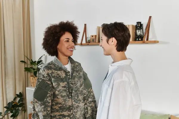 Una despedida conmovedora mientras un soldado se prepara para el servicio, abrazando a su pareja en una sala de estar amorosa. — Stock Photo