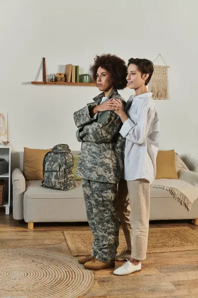 Un sincero adiós entre un soldado y su esposa en una acogedora sala de estar llena de amor. — Stock Photo
