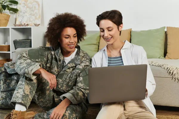 Happy african american female soldier and her girlfriend using laptop, homecoming, lesbian couple — Stock Photo