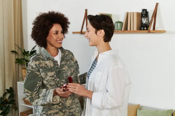 Una sincera despedida mientras un soldado camuflado comparte un tierno momento con su esposa en casa. — Stock Photo