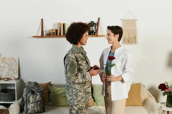 A soldier bids a heartfelt goodbye to her wife, surrounded by love and memories in their warm home. — Stock Photo
