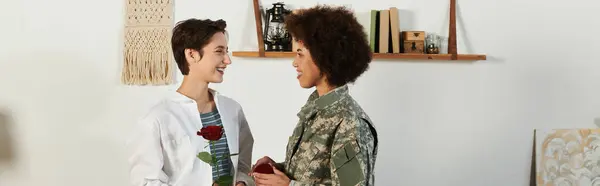 Un soldado se despide de su esposa, intercambiando sonrisas y una rosa en su cálido espacio de vida. — Stock Photo