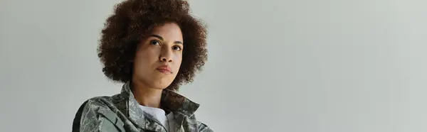 Una joven y decidida mujer afroamericana encarna fuerza mientras usa un uniforme de camuflaje. - foto de stock