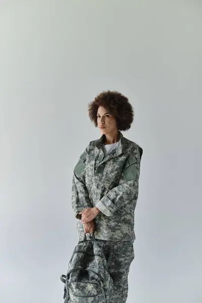 Une jeune femme confiante en camouflage, incarnant force et détermination, se tient prête au devoir. — Stock Photo