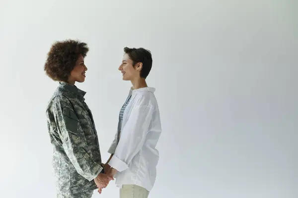 A soldier in uniform and her wife share a heartfelt moment before she heads off to duty. — Stock Photo