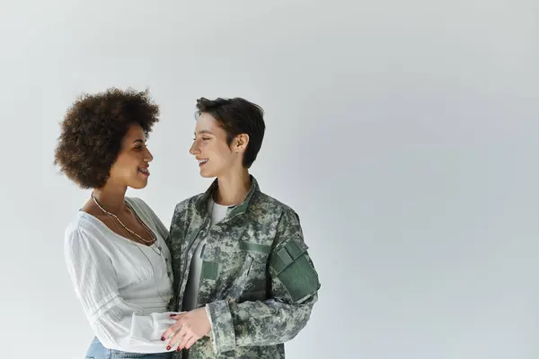 A military soldier bids goodbye to her wife in a tender moment of love and support. — Stock Photo