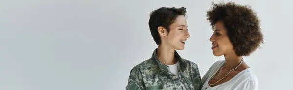 Un abrazo amoroso entre un soldado en uniforme y su esposa, capturando un momento de corazón en un estudio. — Stock Photo