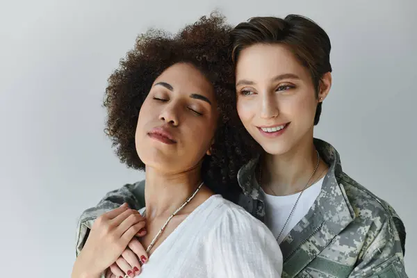A soldier in camouflage embraces her wife, capturing a moment of love and support in a studio. — Stock Photo