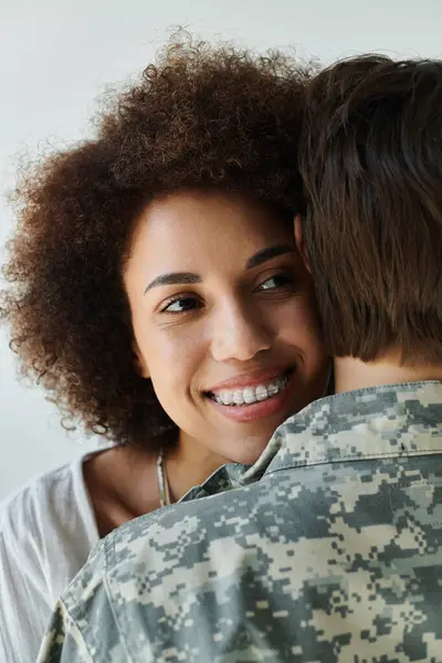 A tender moment shared between a soldier in camouflage and her loving wife. — Stock Photo