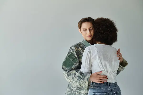 Un abrazo sincero mientras un soldado militar se despide de su esposa en un acogedor estudio. — Stock Photo
