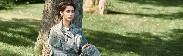 Una joven en uniforme militar disfruta de un momento de reflexión al regresar a casa al aire libre. — Stock Photo