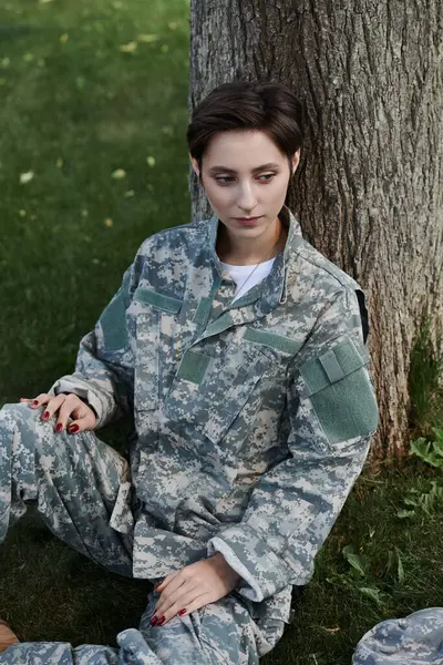 Une jeune femme en camouflage profite d'un moment de paix à l'extérieur après son retour du service militaire. — Photo de stock