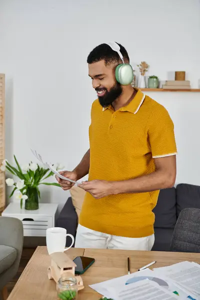 Man immersed in music as he sorts through important papers at home. — Stock Photo