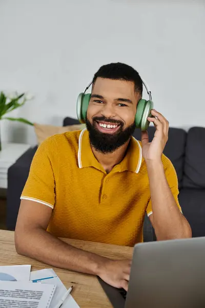 Un homme souriant écoute de la musique à la maison, créant une ambiance joyeuse et détendue. — Photo de stock