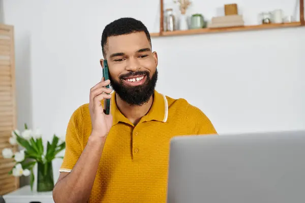 Un uomo sorridente si impegna in una conversazione telefonica nella sua accogliente casa. — Foto stock