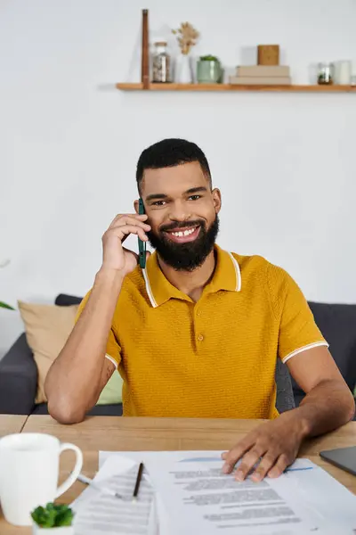 Cheerful man engaged in conversation while surrounded by paperwork. — Stock Photo