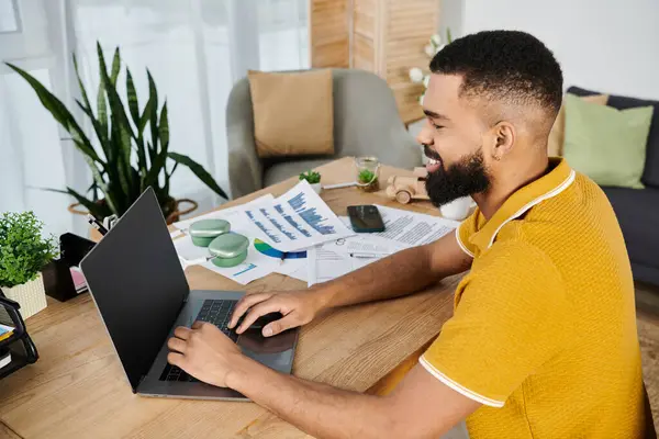 Lächelnder Mann genießt entlegene Arbeit, während er von einem stilvollen Wohnumfeld umgeben ist. — Stockfoto