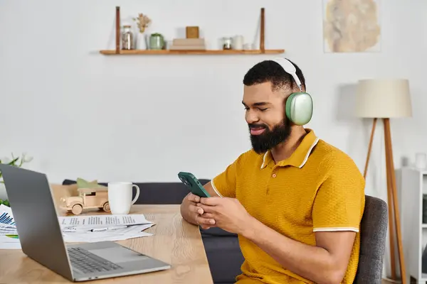 L'uomo rilassato si connette con la tecnologia mentre si gode il suo ambiente domestico accogliente. — Foto stock