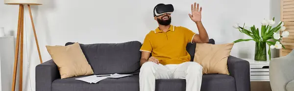 Man engages in immersive virtual reality while relaxing on the sofa. — Stock Photo