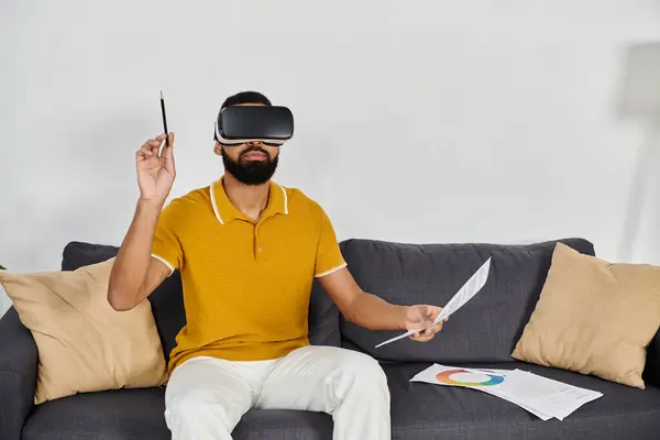 A man enjoys virtual reality while relaxing on his couch. — Stock Photo