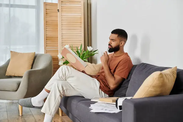 Un uomo premuroso riflette mentre seduto comodamente a casa. — Stock Photo