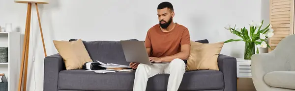 A man focuses intently on his laptop while relaxing at home. — Stock Photo