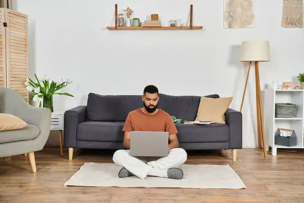 A man enjoys quality time working on his laptop in a stylish living space. — Stock Photo