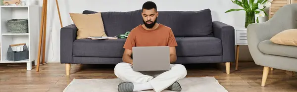 Man focused and working on laptop while enjoying his comfortable living space. — Stock Photo