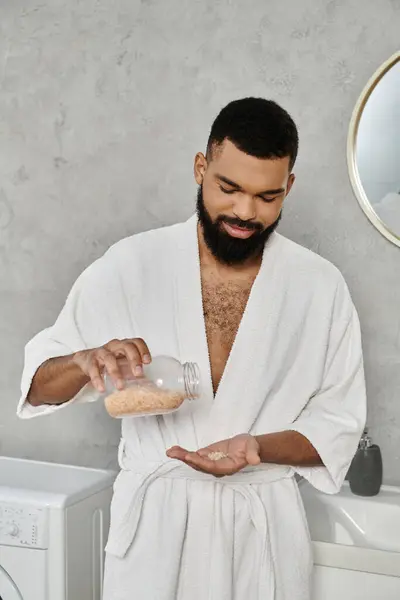 Ein Mann im Mantel gießt Badesalz in die Hand. — Stockfoto