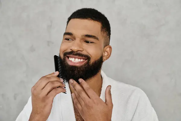 A cheerful man combs his beard while enjoying his morning at home. — Stock Photo