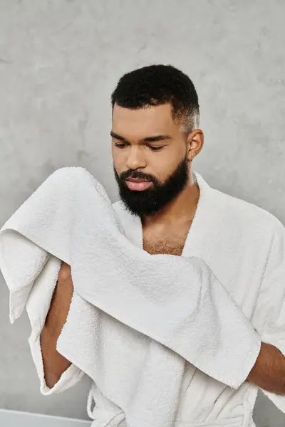 A man enjoying a quiet moment, holding towel, reflecting peacefully at home. — Stock Photo