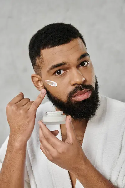 A man cares for his skin while enjoying his time indoors. — Stock Photo