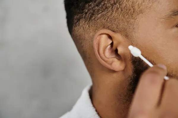 Man carefully grooming his beard with a cotton swab at home. — Stock Photo
