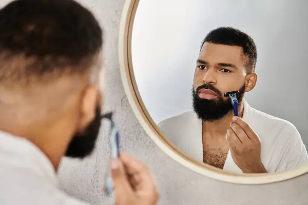 Uomo accuratamente rasatura mentre godendo di un momento di tranquillità in bagno elegante. — Foto stock