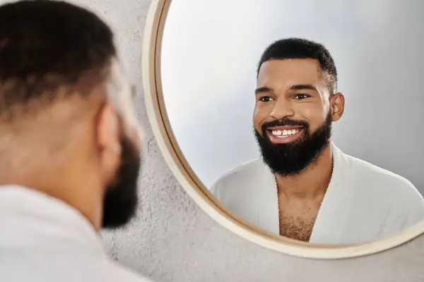 Smiling man admires himself in the mirror while relaxing at home. — Stock Photo