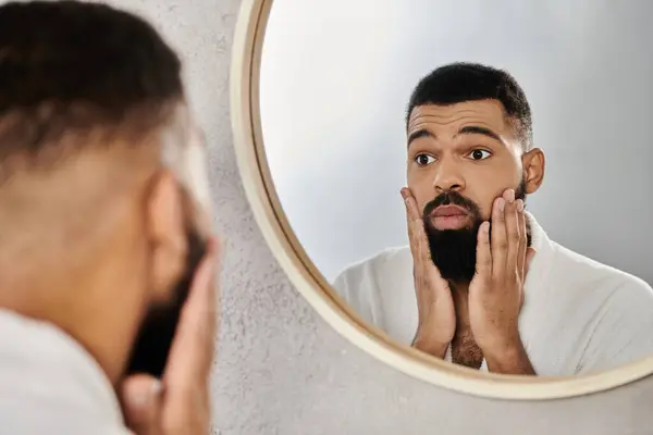 A man enjoys a quiet moment, grooming in front of a mirror at home. — Stock Photo