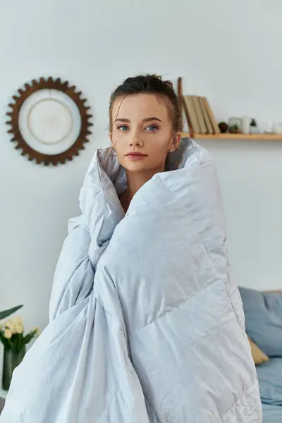 A young woman enjoys the warmth of a blanket on a relaxing morning. — Stock Photo