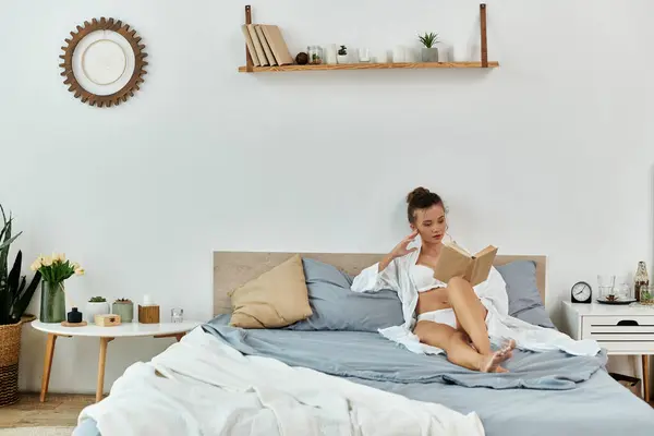 A stylish young woman enjoys reading in her lingerie amidst a serene bedroom. — Stock Photo