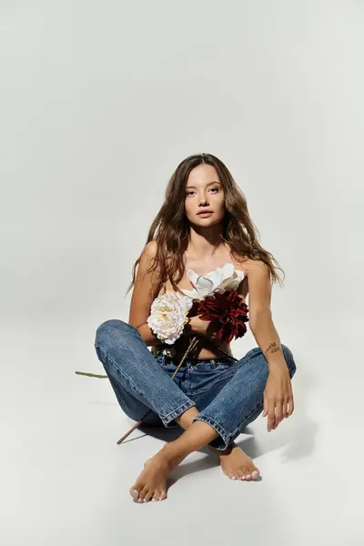 A confident young woman poses with flowers, showcasing her unique style and allure. — Stock Photo