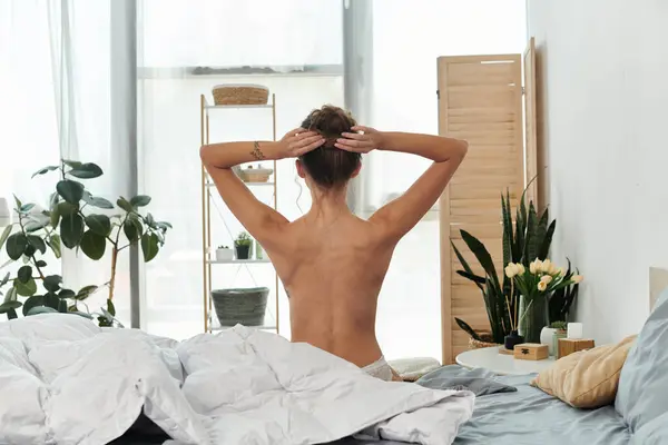 A young woman enjoys a tranquil morning in bed amidst natural decor. — Stock Photo