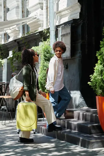 Ein fröhliches Paar steigt Stufen hinauf und umarmt sein Reiseabenteuer durch eine lebendige europäische Stadt. — Stockfoto