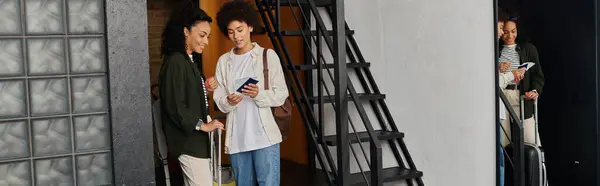 A joyful couple stands in a hostel, sharing travel plans while preparing to explore the area. — Stock Photo
