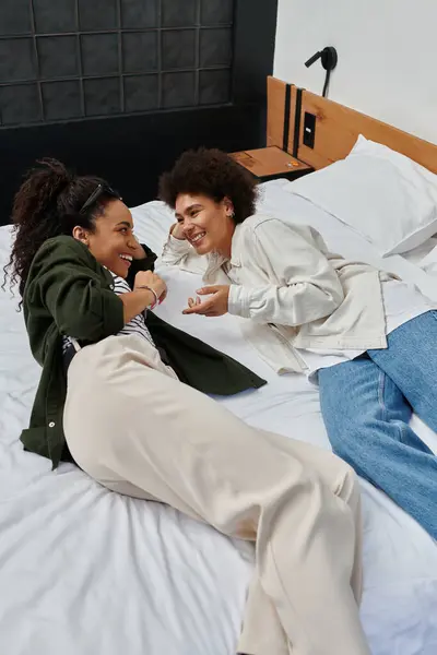A happy couple relaxes and shares laughter in their cozy hotel room, enjoying each other's company. — Stock Photo