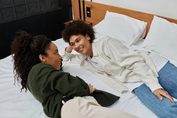 A happy couple shares laughter and love while relaxing together in their cozy hotel room. — Stock Photo