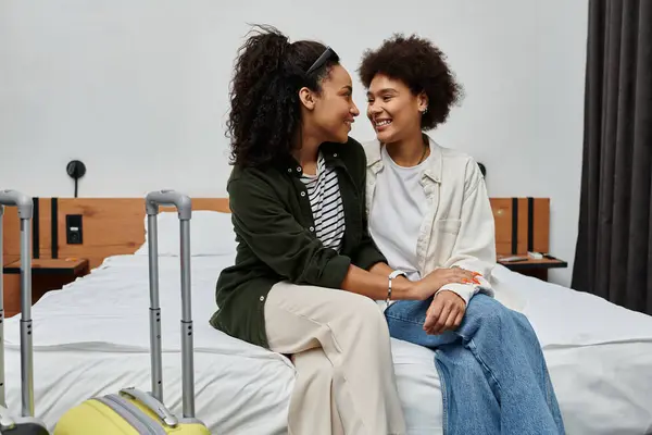 The couple shares laughter and affection while relaxing on their hotel bed, enjoying their travel adventure. — Stock Photo