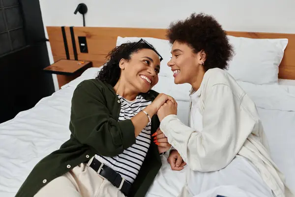 A joyful couple embraces each other while relaxing in their hotel room, celebrating love and adventure. — Stock Photo